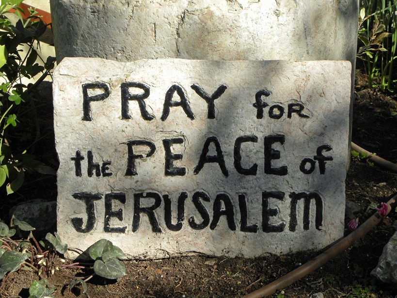 Das Foto zeigt eine Steintafel, in die auf Englisch eingraviert ist "Pray for the peace of Jerusalem", also "Bete für den Frieden Jerusalems". Weil Jerusalem eine wichtige religiöse Stadt für Juden, Christen und Muslime ist, steht das Wort für den Frieden zwischen diesen drei Religionen und für einen friedlichen Zionismus.